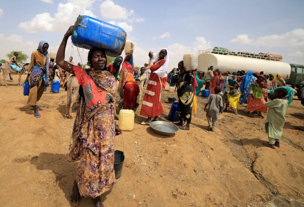 A Sudanese refugee woman, who fled the violence in Sudan's Darfur region, carries a jerrycan of water as she walks to her makeshift shelter near the border between Sudan and Chad in Koufroun, Chad May 10, 2023. REUTERS/Zohra Bensemra     TPX IMAGES OF THE DAY